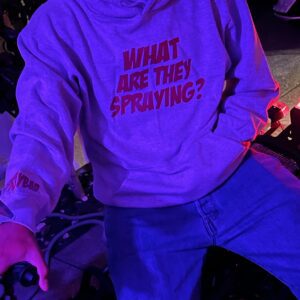 man wearing hoodie with text saying “WHAT ARE THEY SPRAYING?”
